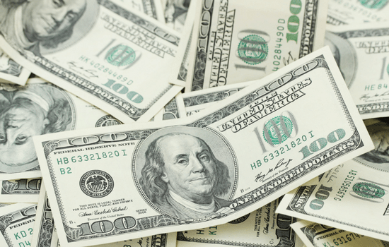 A pile of $100 bills with Benjamin Franklin on them.