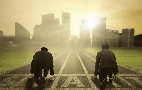 Two accountants lining up at a start line on a track, looking to a cityscape in the background.