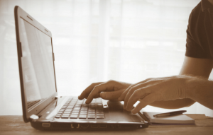 A person typing on a laptop keyboard.