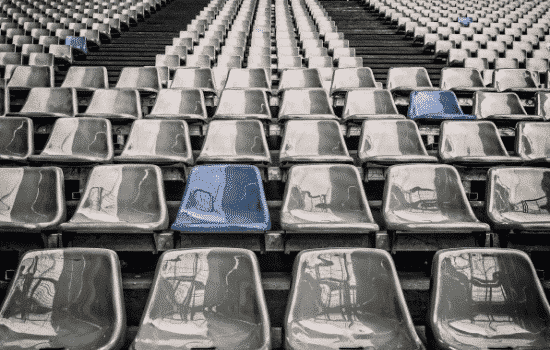 Empty Stadium with two blue chairs in the stands.