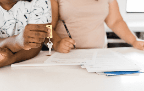 A renter being handed the keys to their property after signing a real estate agreement.