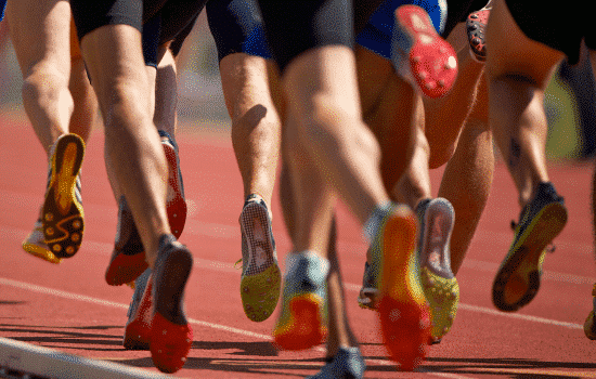 A group of runners running on a rubberized track.