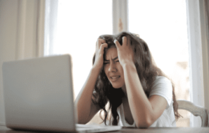 An individual frustrated while working on a computer.