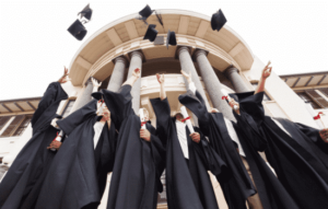 A group of graduates tossing up caps and gowns in a celebratory fashion.
