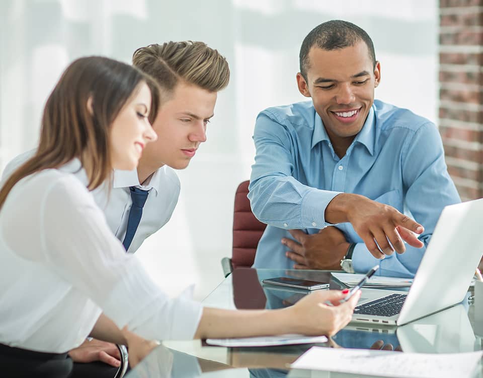 employees talking to a customer sitting at the Desk in the office.