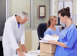 Healthcare staff reviewing financial data at a desk in a joint working area.