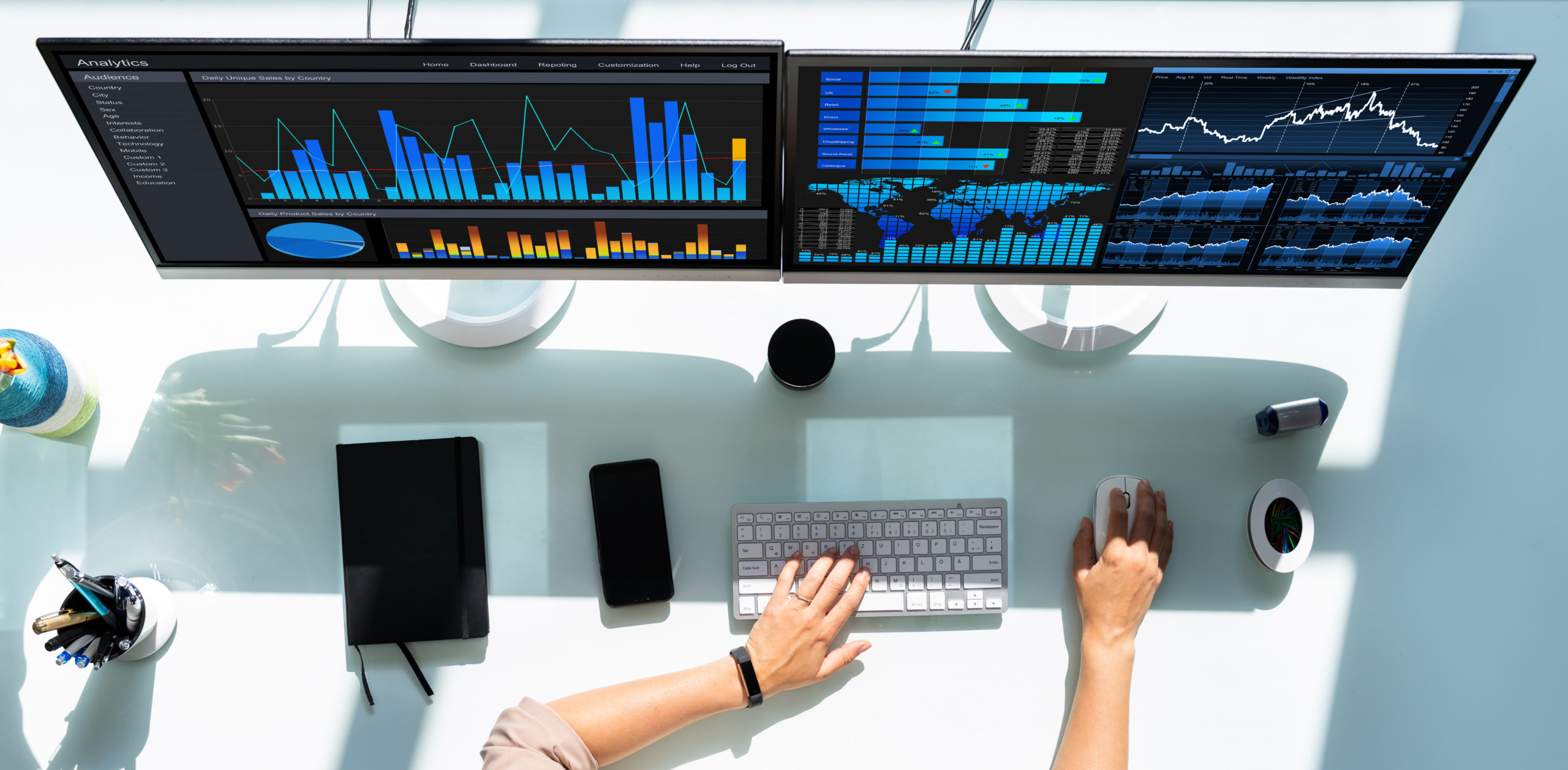 A work environment with two computer monitors, a keyboard, and other desk items.