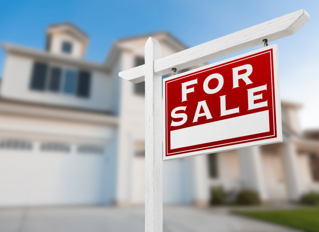 A for sale sign is shown in front of a large house.