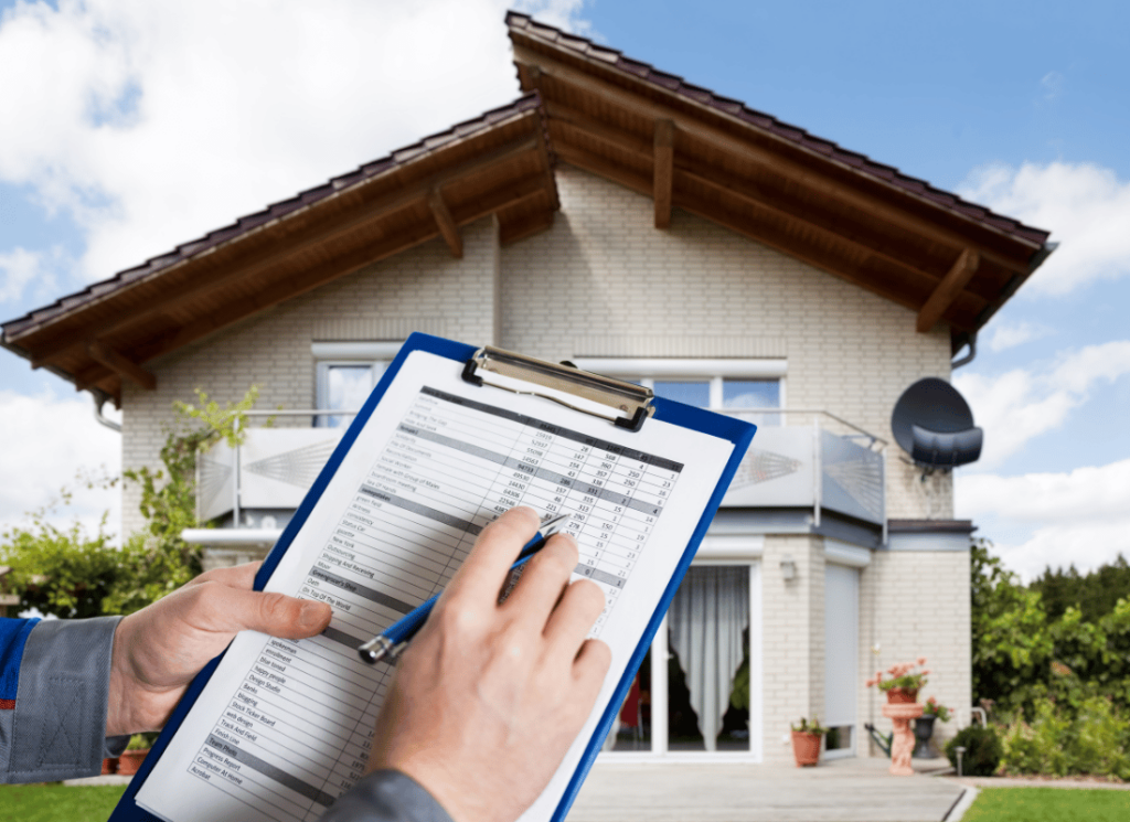 A person is standing outside of a home holding a clip board and pen. The clip board and the person's hands are visible in front of the house.