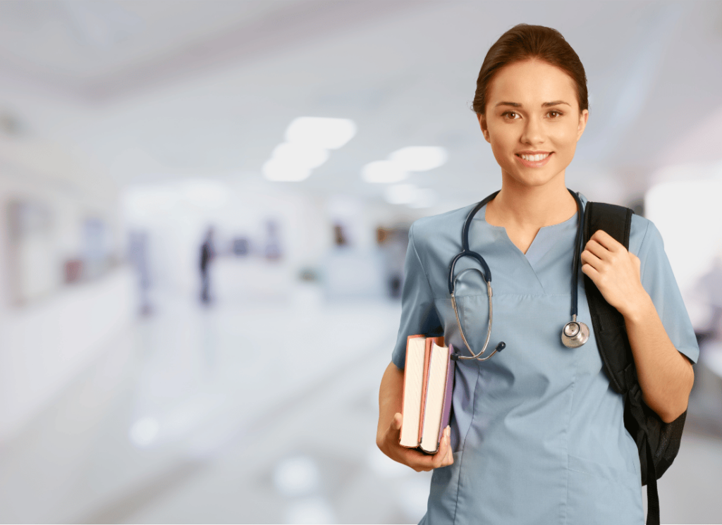A nurse is carrying a bag and books. She has a stethoscope and is wearing nurses scrubs.