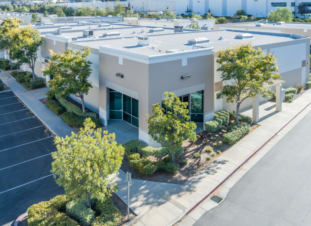 This image shows a building from the outside with trees growing on the surrounding property.