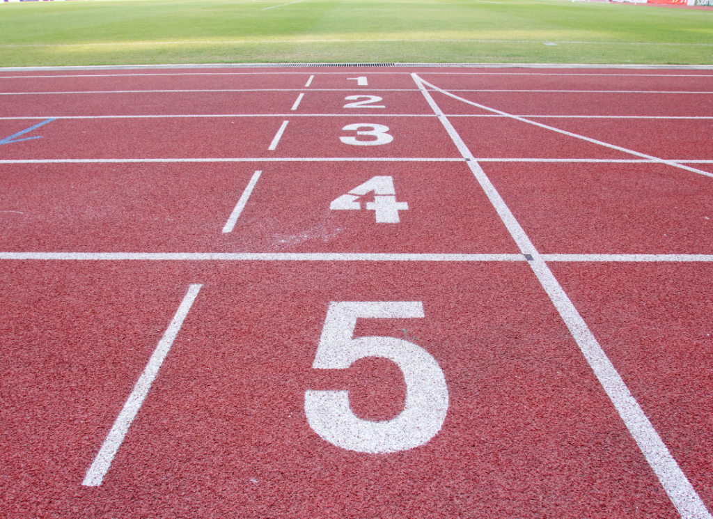 The lanes of a track are shown, numbered one through 5, at a university athletics facility.