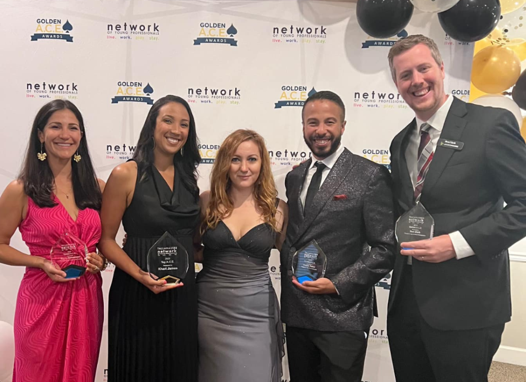 James Moore senior manager Ben Clark stands with fellow recipients holding awards