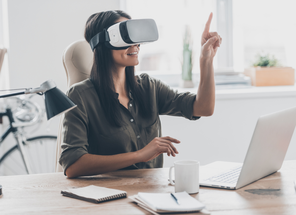 A businesswoman is in an office setting. She is working at her desk while using a VR headset.