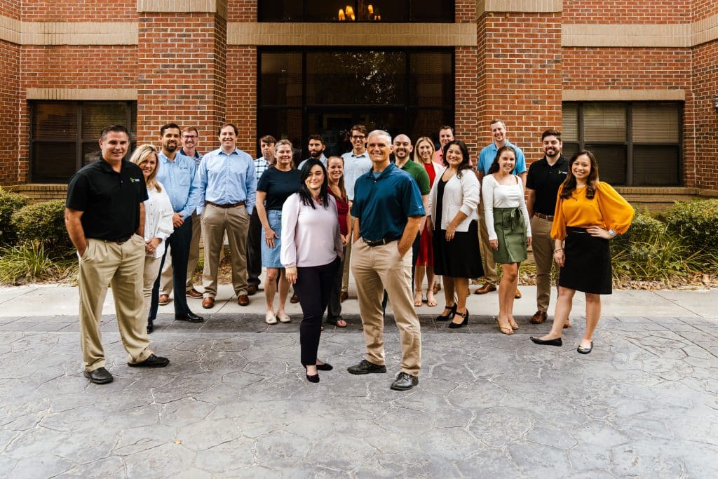 A group photo of all Tallahassee-based James Moore & Co. employees in front of the Tallahassee office.