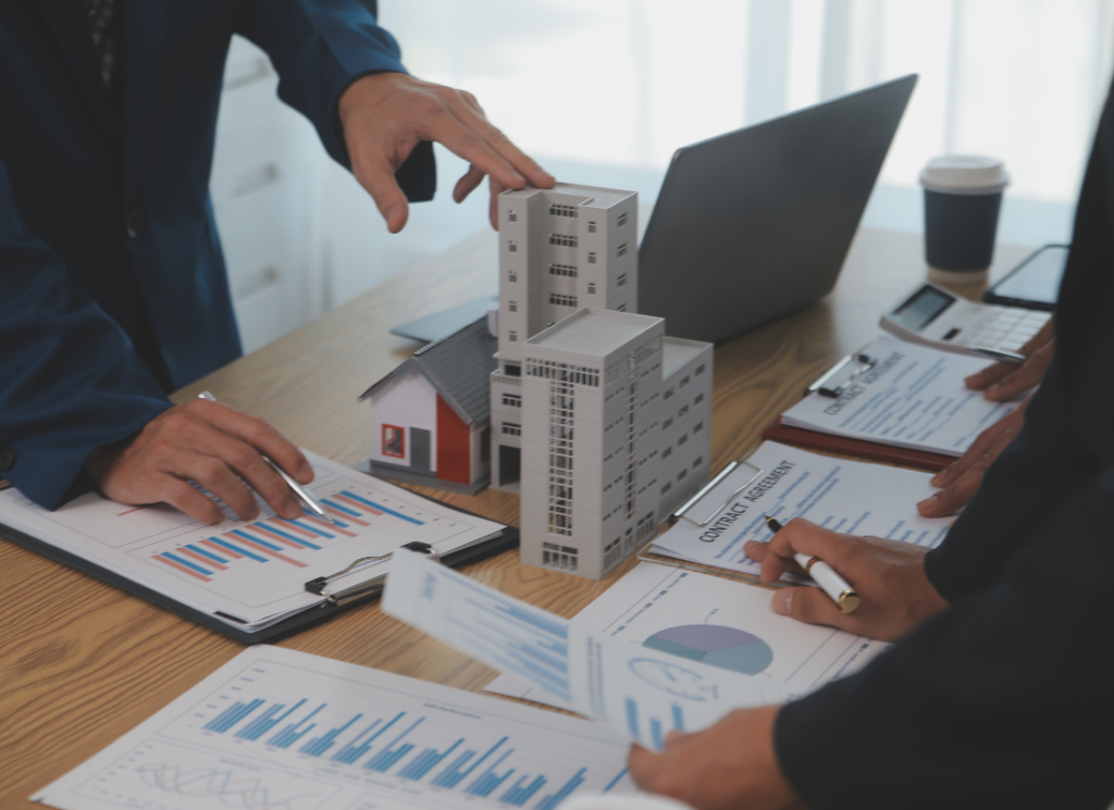 Real estate investors examine a model commercial building and charts with financial data as they explore a cost segregation study.