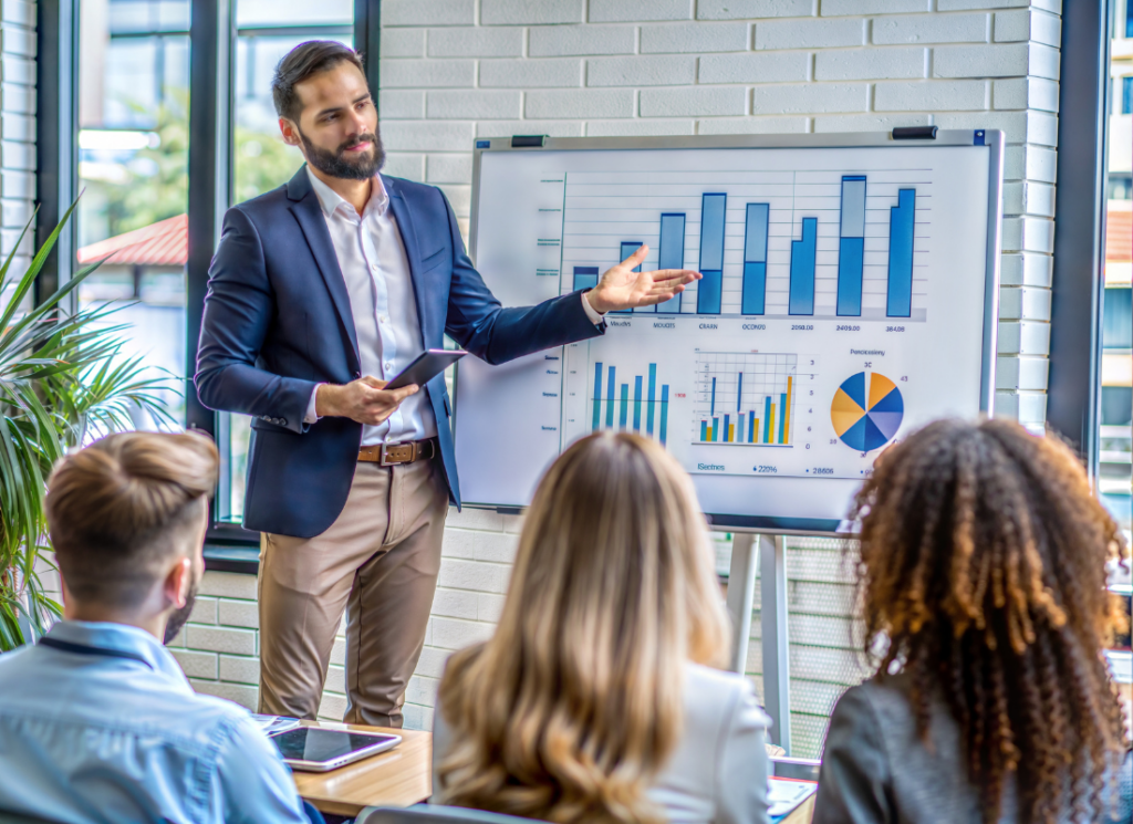 Real estate investors meet in a board room reviewing financial charts and discussing operating performance.