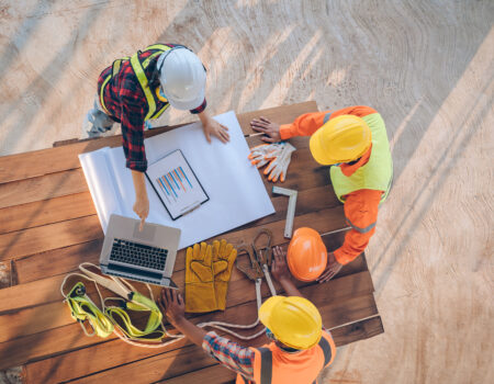 Team of engineer and architects working, meeting, discussing,des Team of engineer and architects working, meeting, discussing,designing, planning, measuring layout of building blueprints at construction site.
