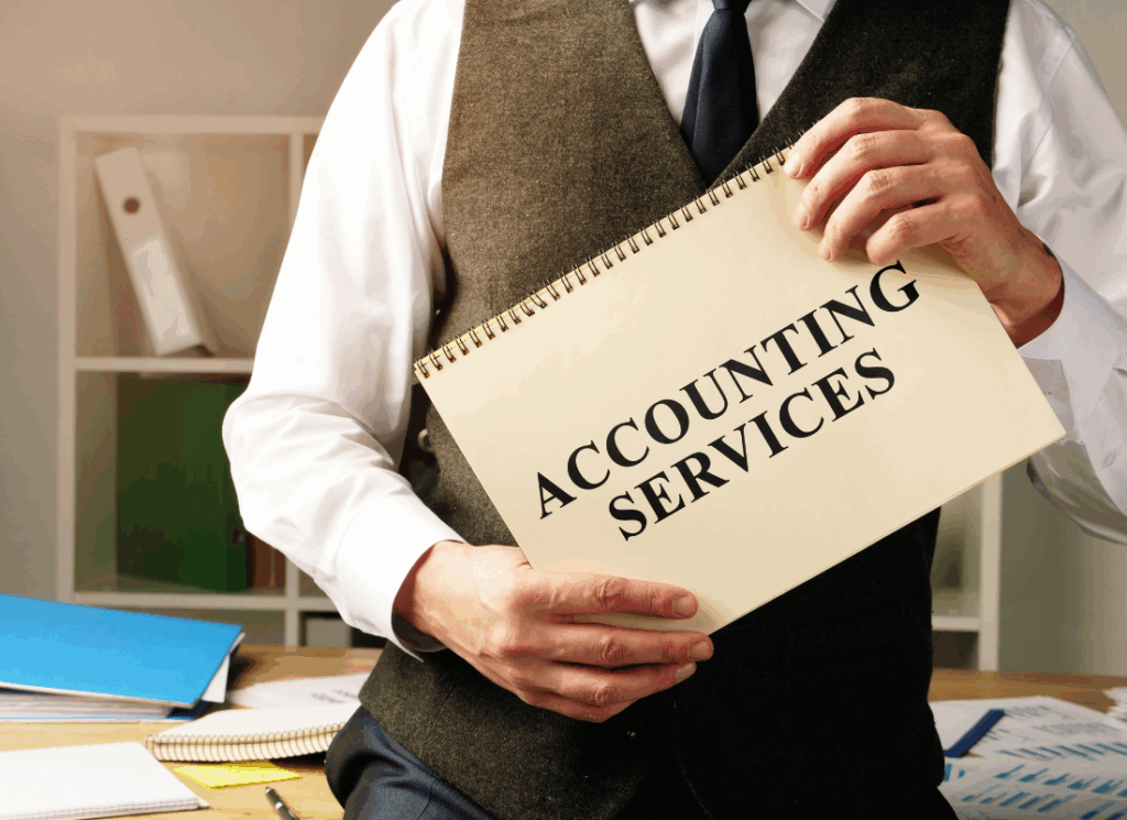 A person in business attire holds a spiral-bound folder labeled “Accounting Services,” symbolizing professional support through outsourced accounting for government entities.