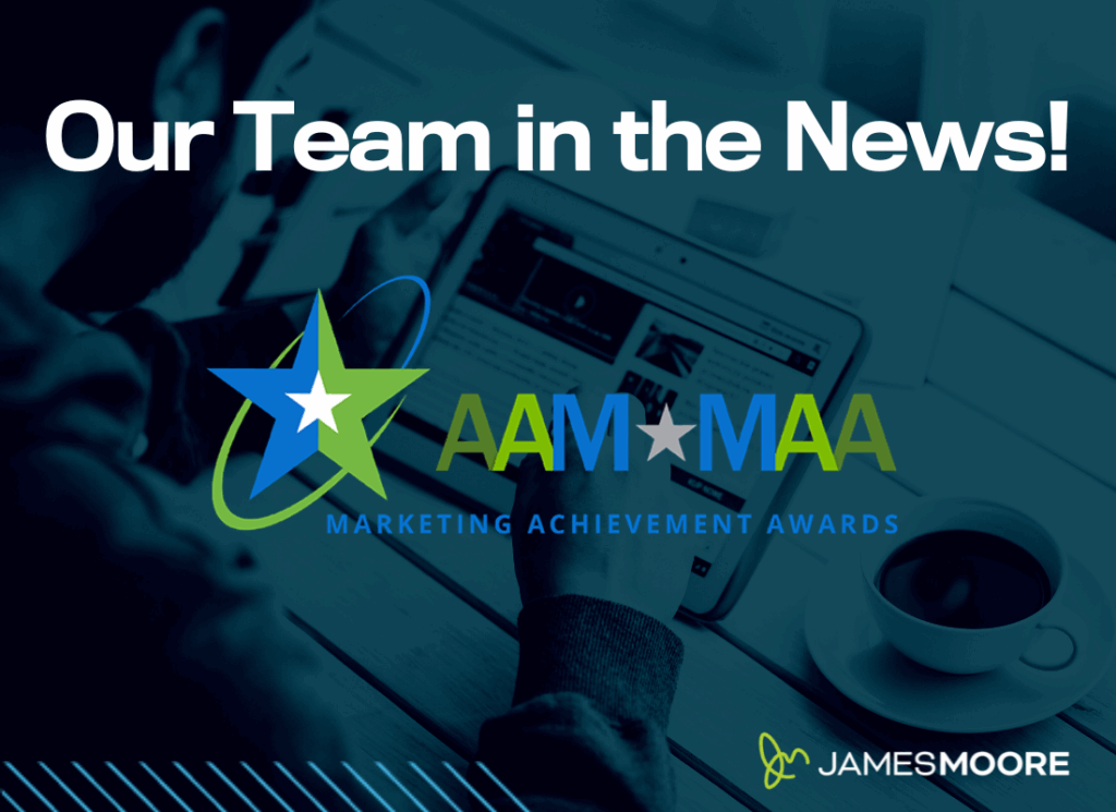 The AAM Marketing Achievement Awards logo on a background that shows a person using a tablet with a coffee cup nearby, and large white text reads “Our Team in the News!” with the James Moore logo in the corner.