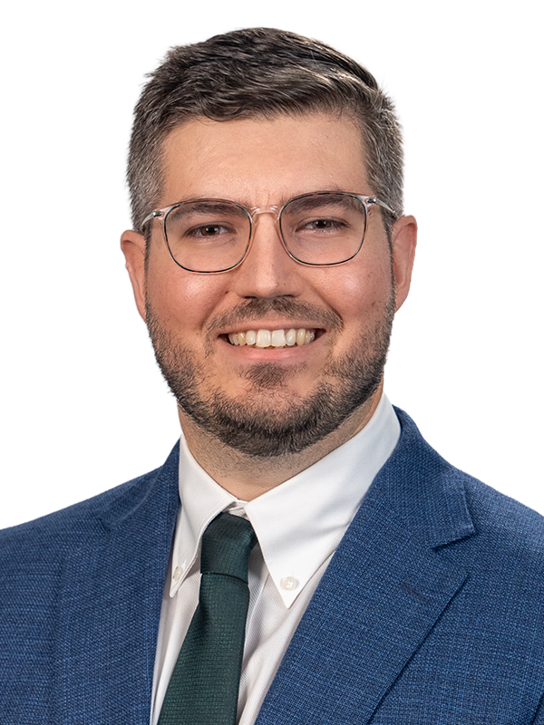 Professional headshot of Caleb Brogan in blue to green gradient overlay.