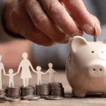 Hand placing coin in piggy bank with paper cutout family standing on stacked coins, symbolizing the tax-deferred savings and Trump Accounts.