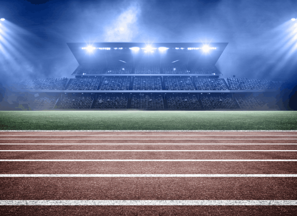 A stadium with bright lights shining over a track and field, symbolizing athletic department brand value and campus visibility.
