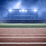 A stadium with bright lights shining over a track and field, symbolizing athletic department brand value and campus visibility.