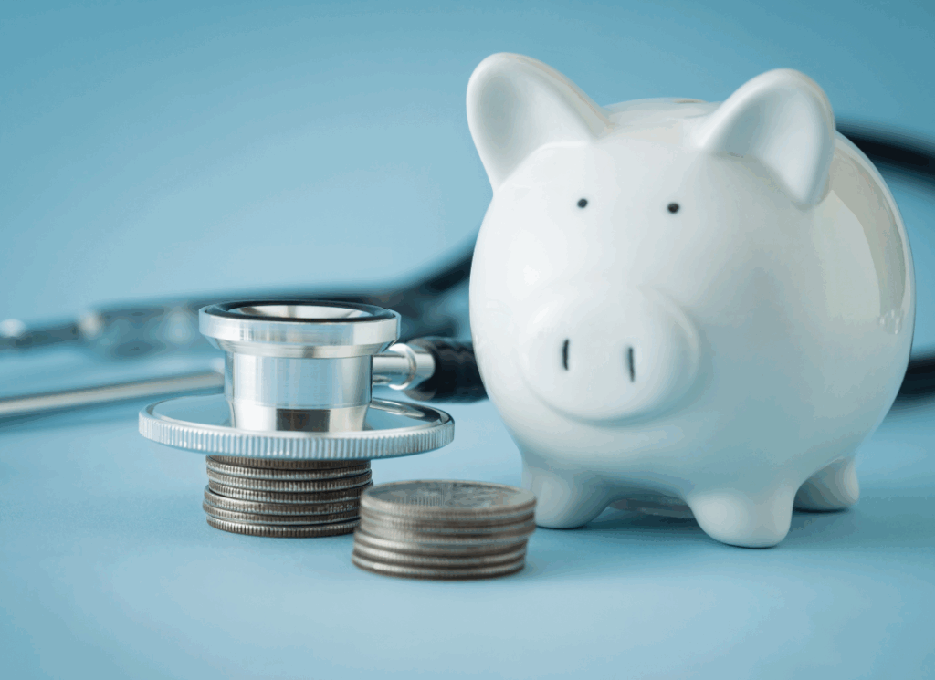 A piggy bank, stethoscope, and stacked coins symbolizing healthcare funding and practice acquisition financing.