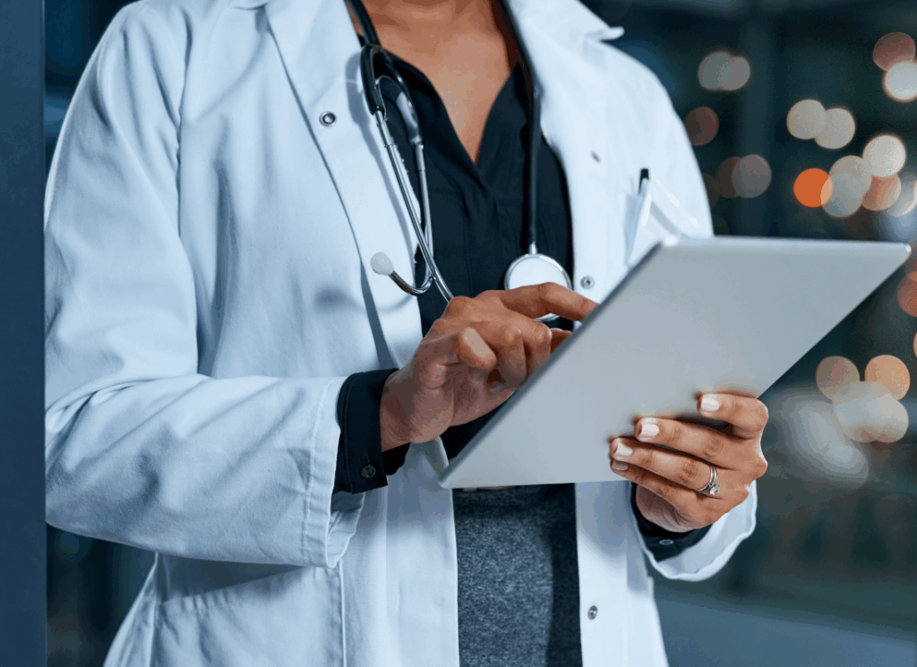A doctor reviews information on a tablet while wearing a lab coat and stethoscope, illustrating bookkeeping for medical practices.