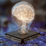 lightbulb containing an illuminated human brain; sits on top of a computer processing chip