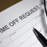 Uncompleted form to request time off, with a pen and glasses sitting on top of it