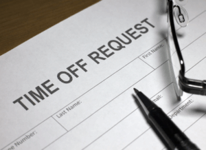 Uncompleted form to request time off, with a pen and glasses sitting on top of it