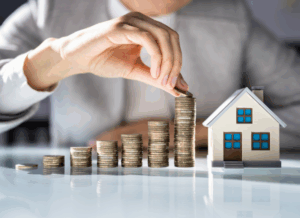 Hand stacking coins beside a model house, illustrating profit distribution and returns in a Real estate waterfall investment structure.