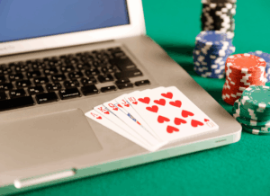 Playing cards and poker chips beside a laptop illustrate the gambling loss deduction limit under the One Big Beautiful Bill Act.