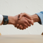handshake showing business casual clothing and boardroom table