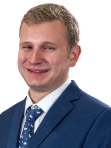 Spencer Machuga's headshot, wearing suit and tie