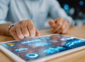 closeup of man's hands as he looks at graphs and charts on a tablet (financial dashboard)