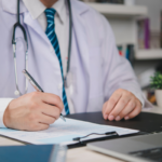 Physician reviewing financial documents while planning medical practice sale with advisory team