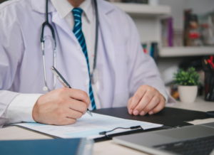 Physician reviewing financial documents while planning medical practice sale with advisory team