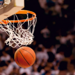 basketball going through hoop, with crowd blurred in the background