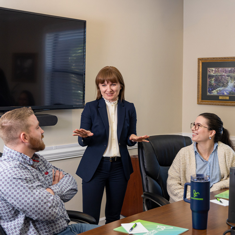 Three professionals collaborating during a team meeting in a conference room.