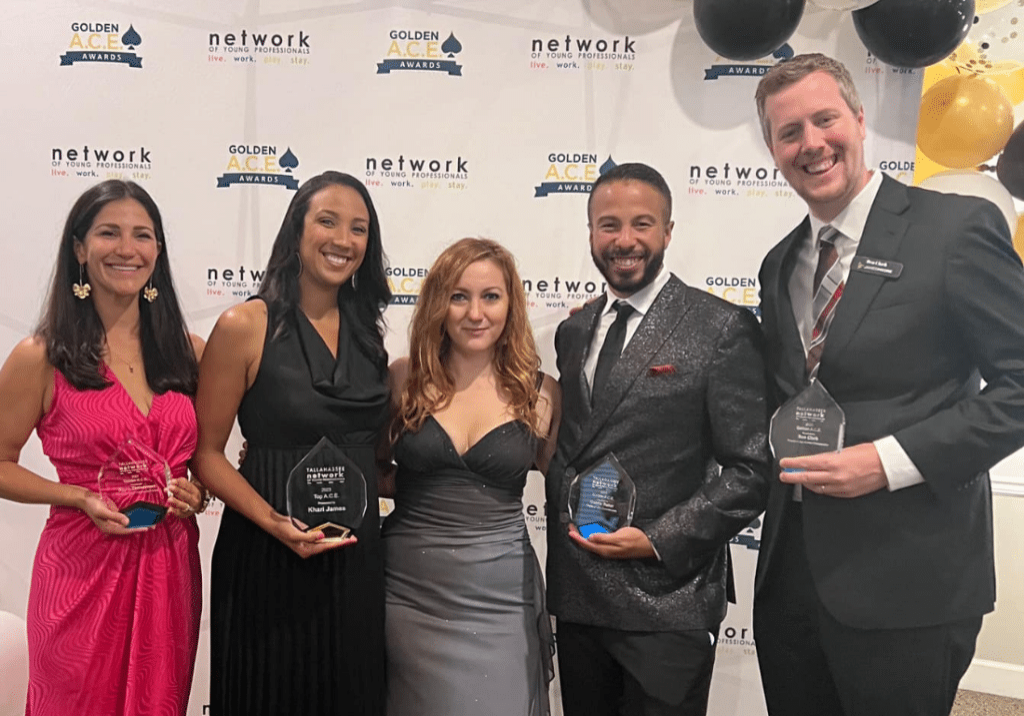 James Moore senior manager Ben Clark stands with fellow recipients holding awards