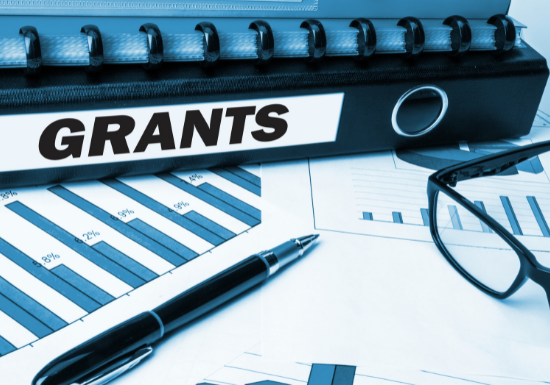 grant binder with financial charts and glasses