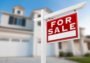 featured image 1100 x 800 (22) A for sale sign is shown in front of a large house.