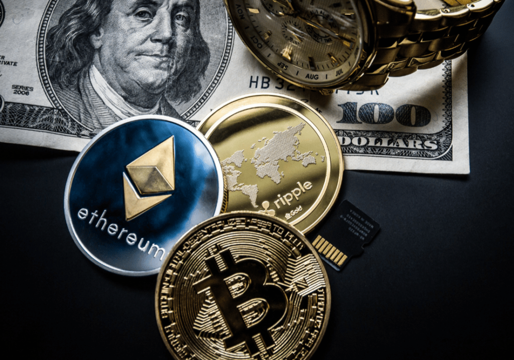 featured image (19) A $100 bill, a gold watch and 3 cryptocurrency coins are shown on a black background. The coins represent Bitcoin, Ethereum, and Ripple cryptocurrencies.